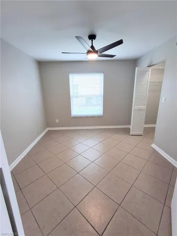 Unfurnished room featuring light tile patterned floors and a ceiling fan