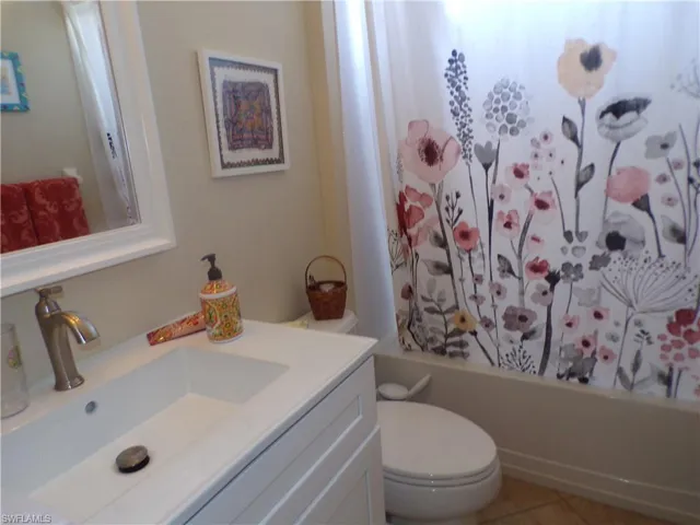 Bathroom with vanity, shower / bath combo, and light tile patterned floors