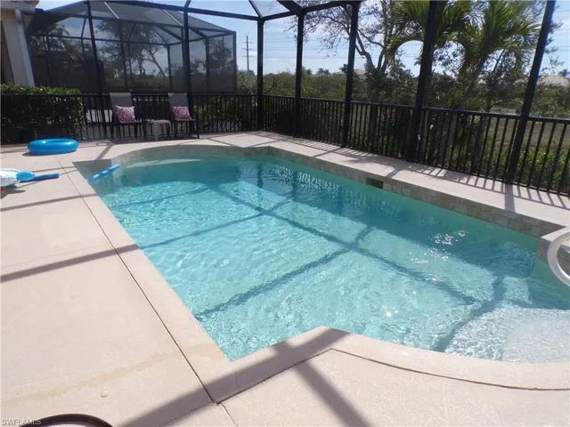 View of pool with a lanai, a sunroom, and patio surround