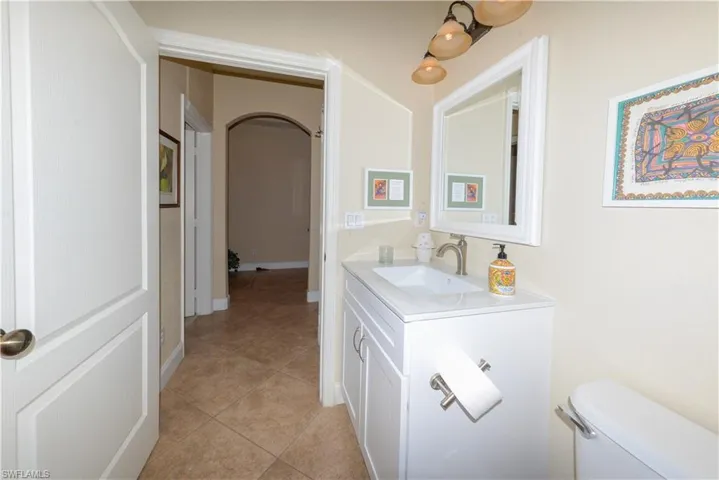 Half bath with vanity and light tile patterned flooring