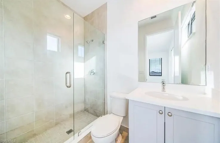 Bathroom featuring a shower stall and vanity