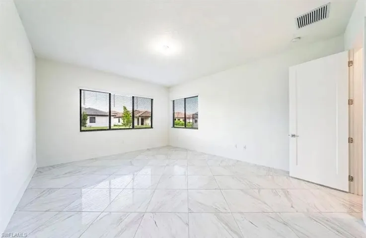Spare room featuring light marble finish floors