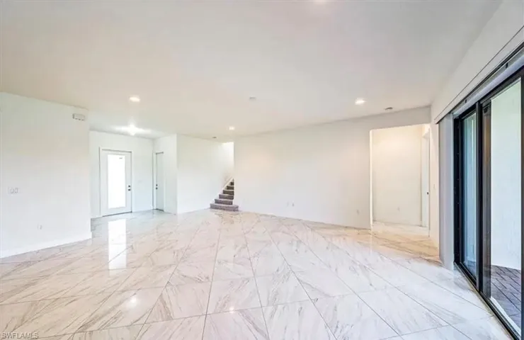 Spare room with recessed lighting, stairs, and light marble finish flooring