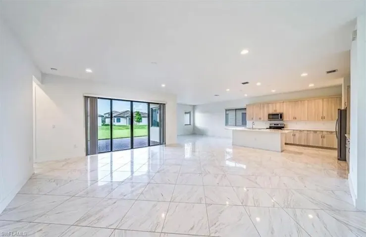 Unfurnished living room with recessed lighting and light marble finish flooring