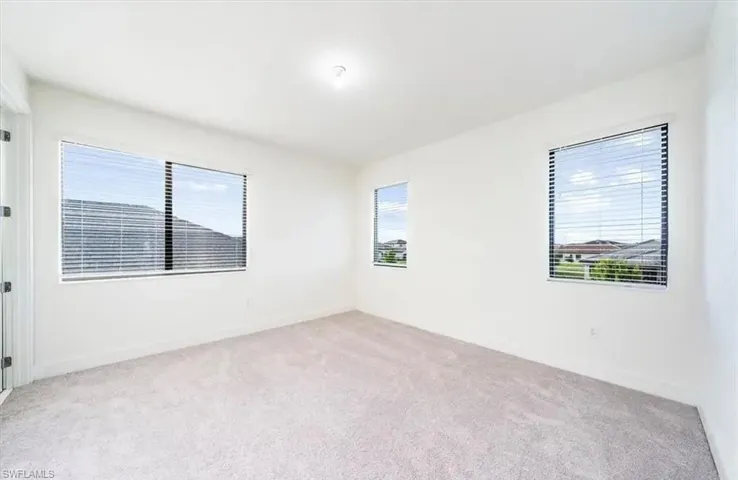Empty room featuring light colored carpet and baseboards
