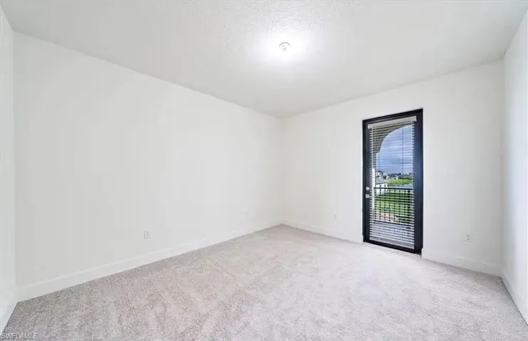 Unfurnished room featuring light carpet and a textured ceiling