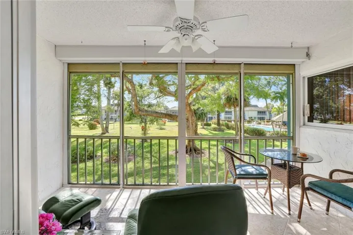 Sunroom / solarium featuring a textured wall, ceiling fan, plenty of natural light, and a textured ceiling