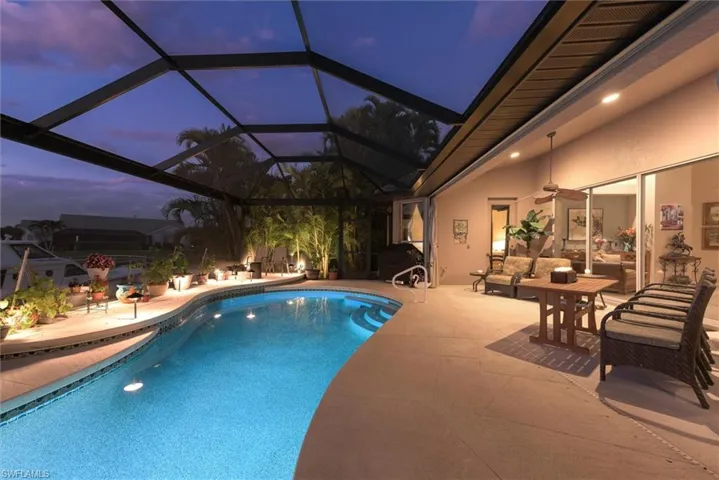 Swimming pool with a patio, an outdoor lounge area, a sunroom, and a lanai