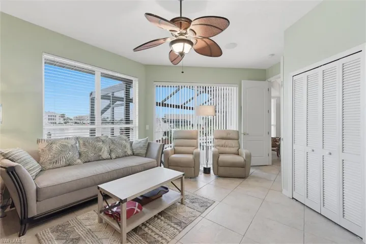 Living area featuring a ceiling fan and light tile patterned flooring