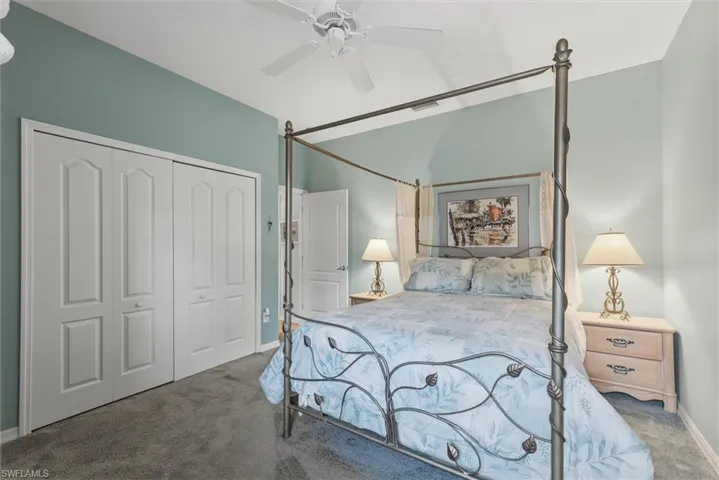 Bedroom featuring dark colored carpet, a ceiling fan, and a closet