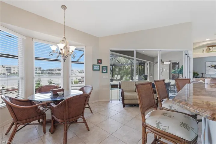 Dining space with a sunroom, suspended lighting, and light tile patterned floors