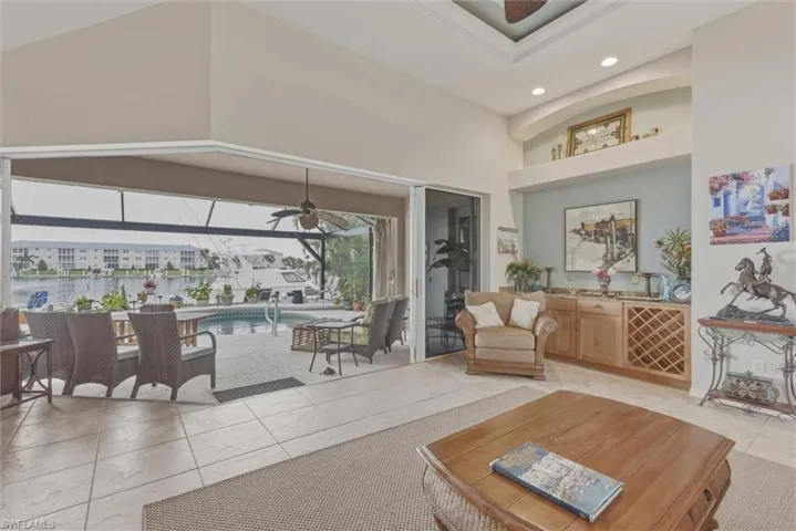 Living room with a sunroom, ceiling fan, a high ceiling, and recessed lighting