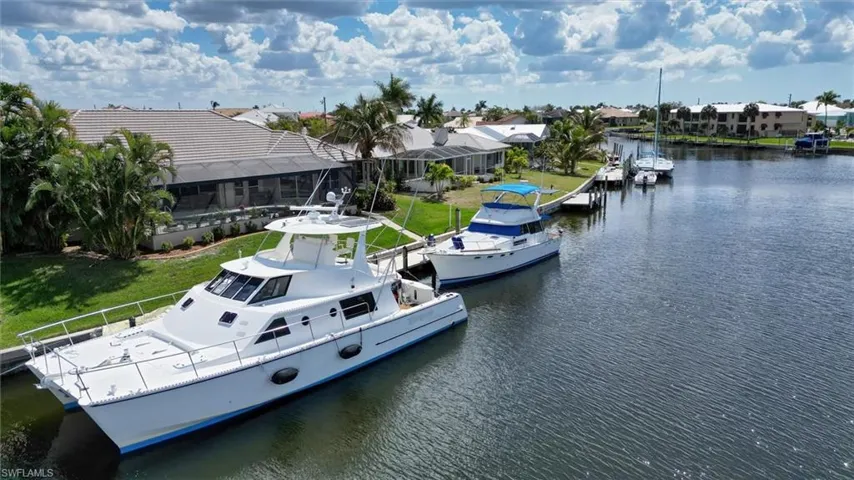 Dock with a water view, a yard, a residential view, and a lanai