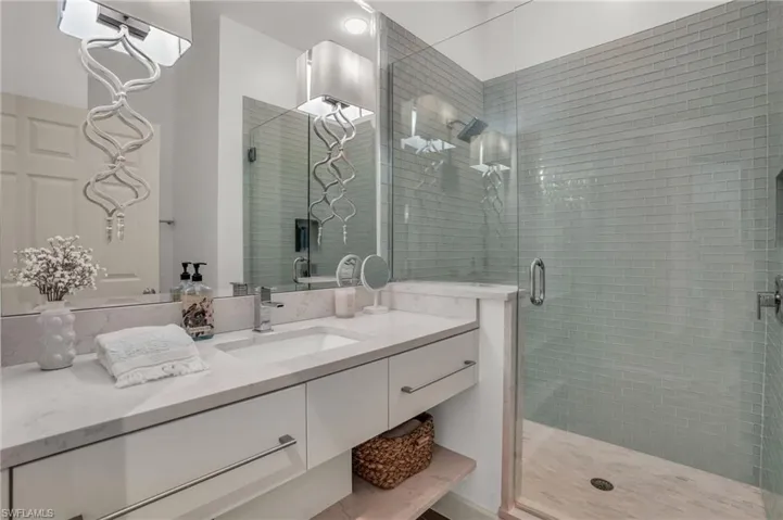 Bathroom with a shower with shower door and vanity