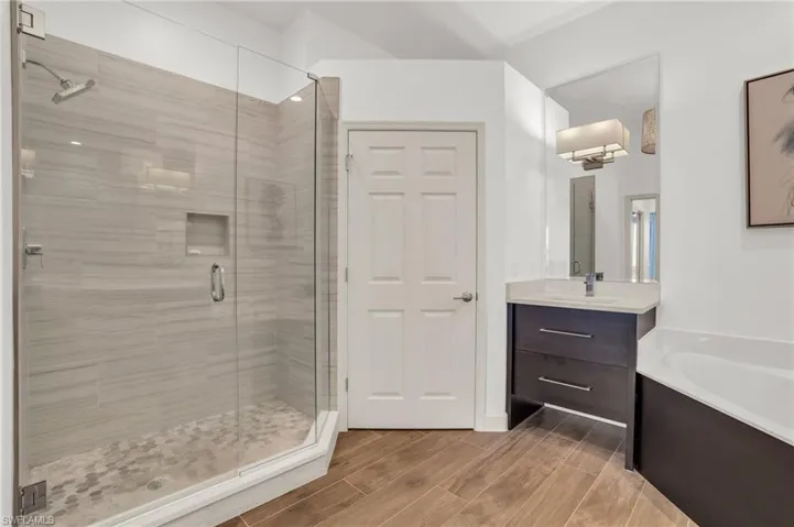 Bathroom featuring vanity, independent shower and bath, and hardwood / wood-style flooring