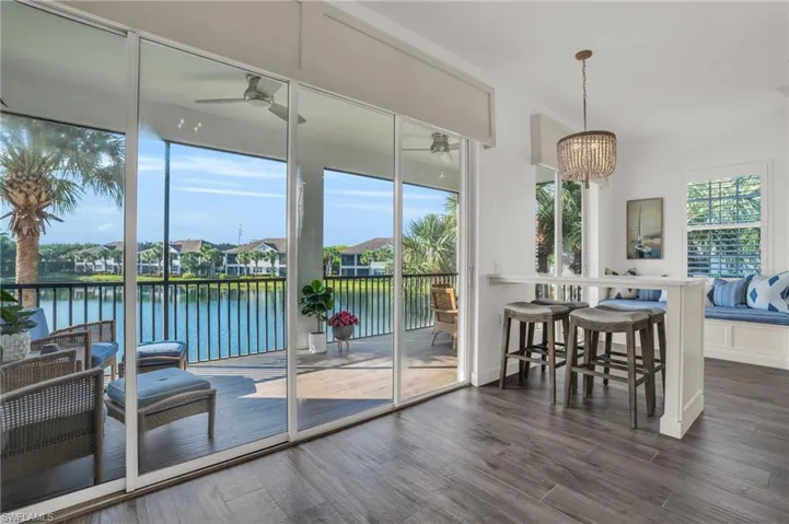Dining room with dark hardwood / wood-style floors, a water view, and ceiling fan with notable chandelier