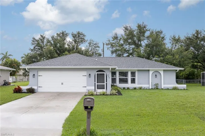 Single story home featuring stucco siding, a front yard, concrete driveway, and a shingled roof
