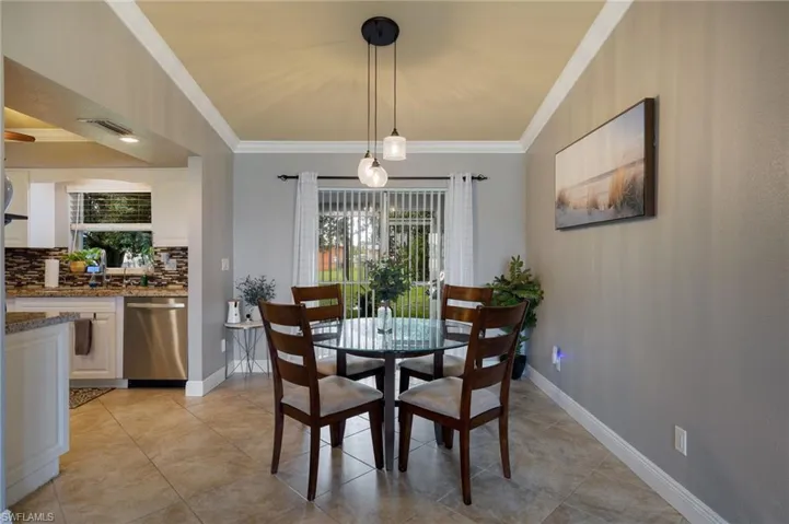 Dining room featuring ornamental molding and light tile patterned floors
