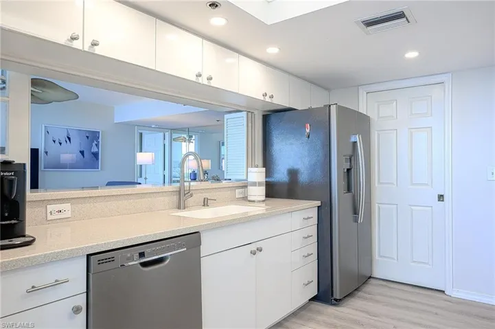 Kitchen with white cabinetry, sink, light hardwood / wood-style floors, and stainless steel appliances
