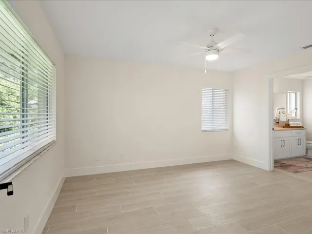 Unfurnished bedroom featuring ensuite bathroom and ceiling fan