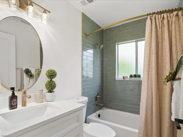 Full bathroom with shower / bath combo, toilet, and vanity