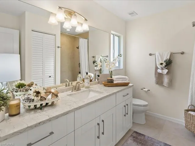 Bathroom featuring tile patterned floors, vanity, and toilet