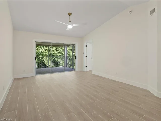 Unfurnished room with light wood-type flooring, ceiling fan, and vaulted ceiling