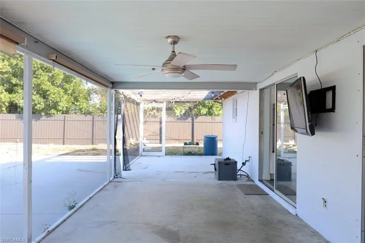Fenced backyard with a ceiling fan and a patio