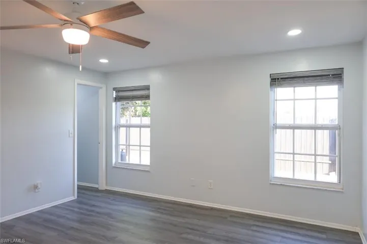 Spare room with dark wood-style flooring, recessed lighting, and a ceiling fan