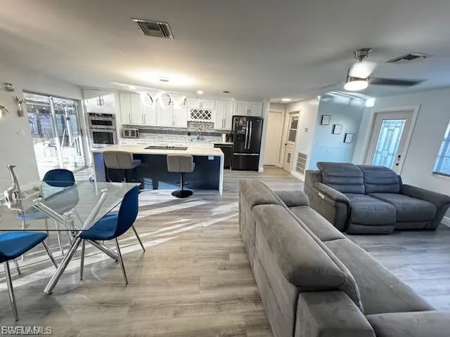Living area featuring light wood-style flooring and a ceiling fan