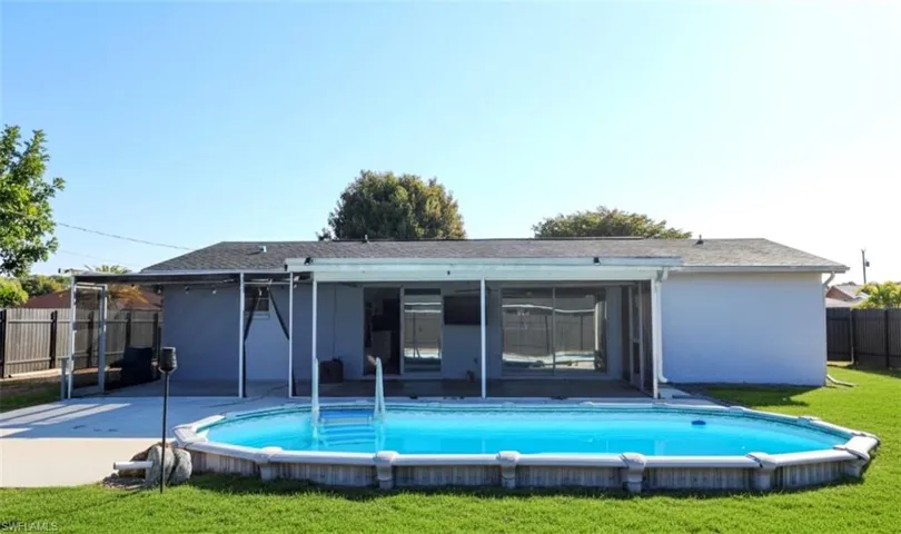 Rear view of property with a fenced backyard, a sunroom, and a patio area