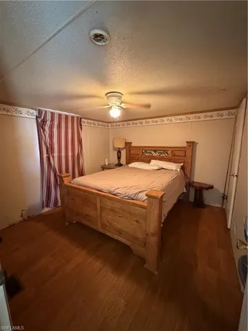 Bedroom featuring wood finished floors, a textured ceiling, and a ceiling fan