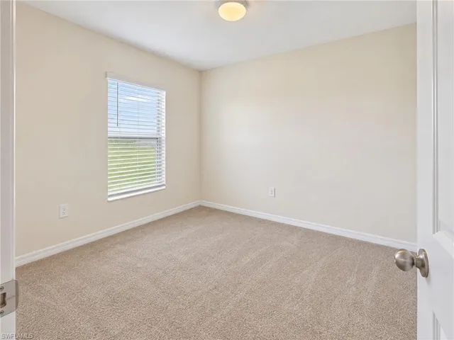 Carpeted flooring, neutral wall tones, window with blinds, and ceiling-mounted light fixture