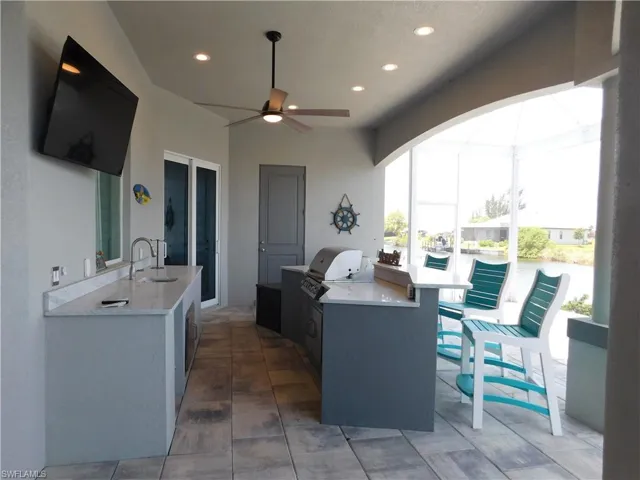 View of patio with grilling area, sink, area for grilling, and ceiling fan