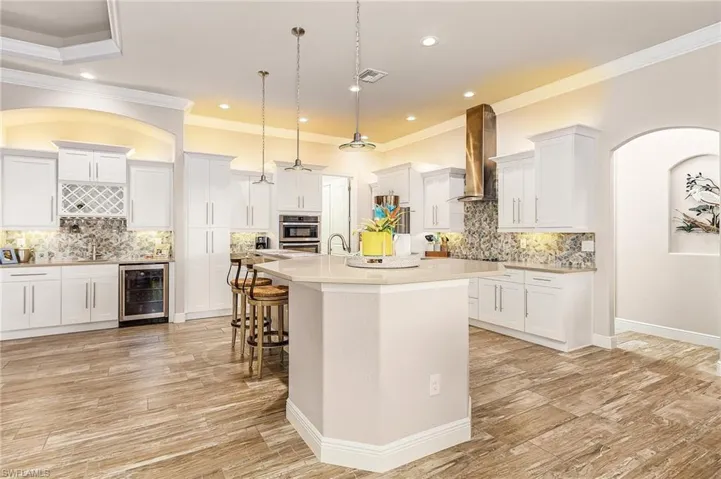 Gourmet kitchen with, island, built-in appliances, tile backsplash