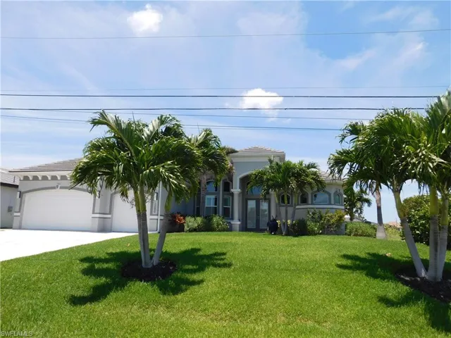View of front facade featuring a garage and a front lawn