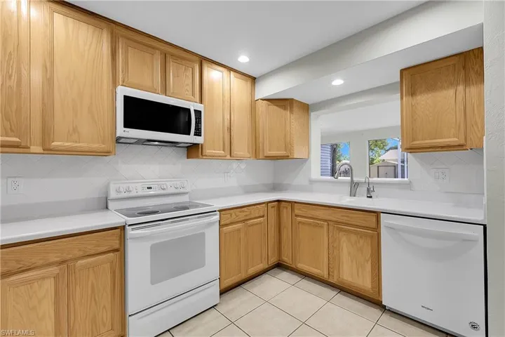 Light oak wood cabnitry with Corian countertop and continuous edge sink