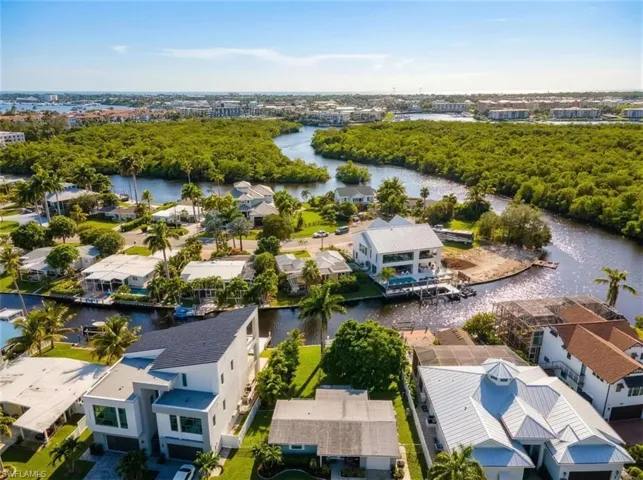 Waterfront properties with direct canal access, surrounded by lush natural landscaping and mature palm trees