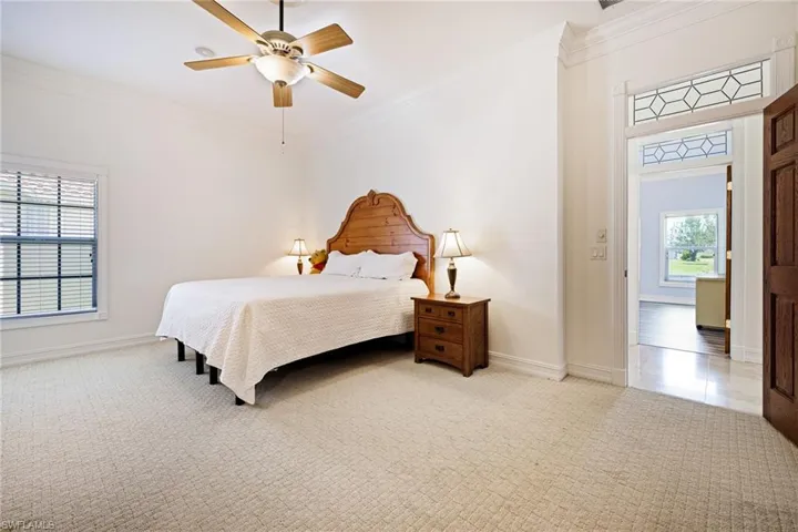 2nd Primary Suite  with light carpet, a ceiling fan, baseboards, and crown molding