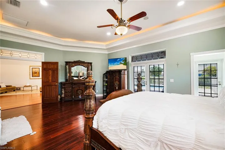 Bedroom featuring multiple windows, visible vents, ornamental molding, and access to exterior