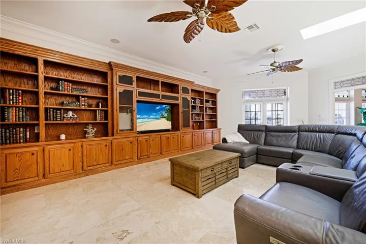 Living area featuring crown molding, visible vents, a ceiling fan, and a skylight