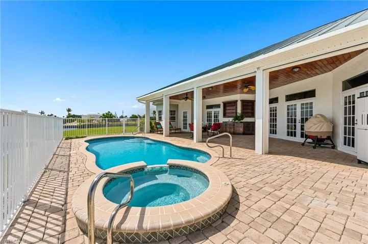 View of swimming pool with a ceiling fan, a fenced backyard, french doors, a patio, and a pool with connected hot tub