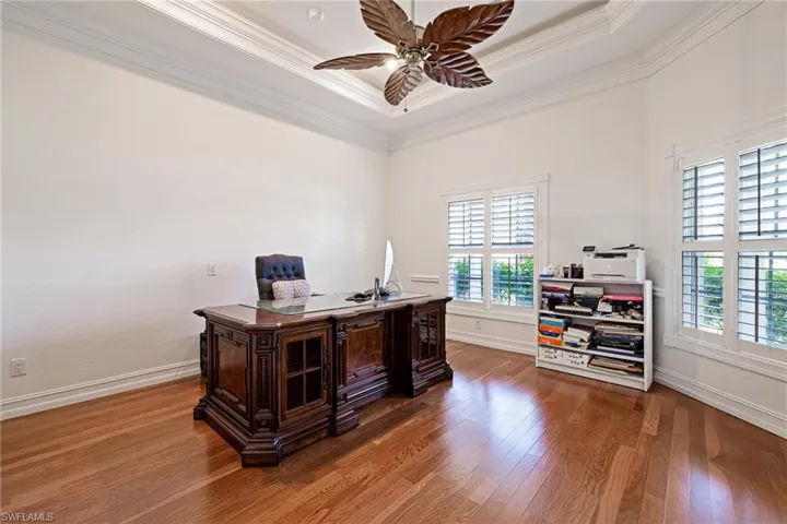 Home office with plenty of natural light, wood finished floors, and crown molding