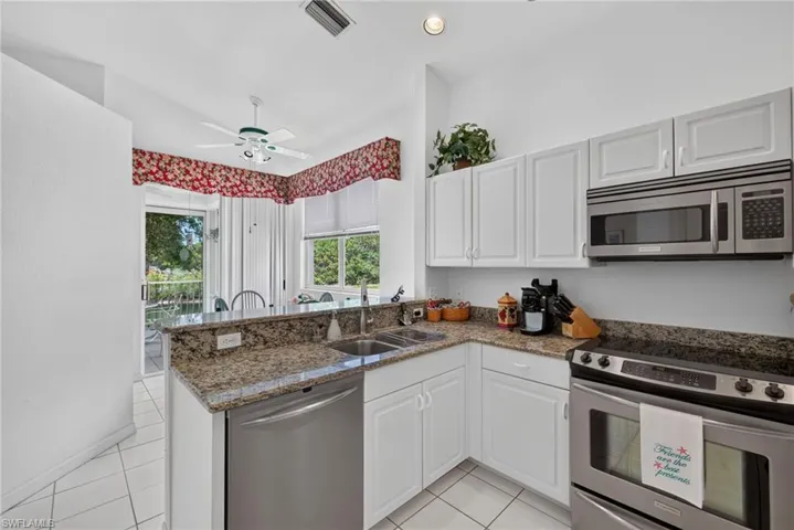 Kitchen to breakfast nook and lanai. Wall to left is non-load bearing and removal would open up the space