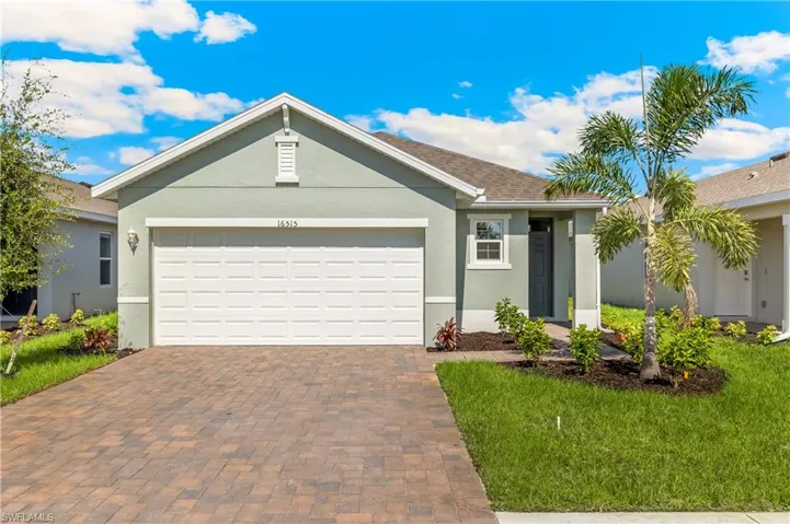 Ranch-style home with decorative driveway, stucco siding, a garage, and a front yard