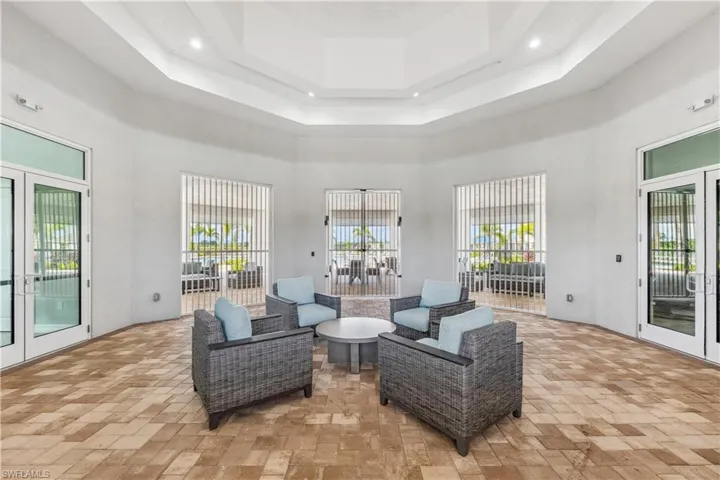 Sitting room with a high ceiling, french doors, a raised ceiling, and recessed lighting
