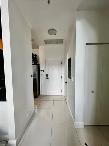 Hallway featuring light tile floors