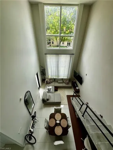 Unfurnished living room with a high ceiling and tile floors