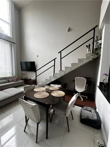 Dining area featuring a towering ceiling and light tile floors