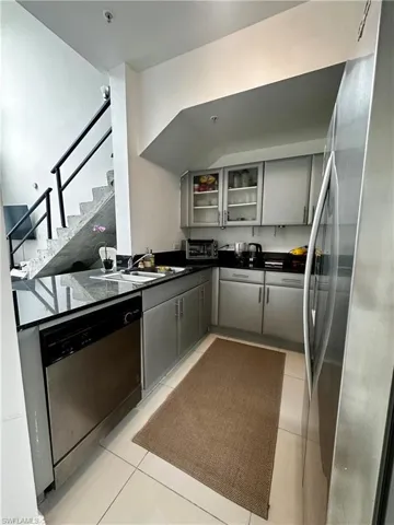 Kitchen featuring stainless steel appliances, gray cabinetry, sink, and light tile flooring